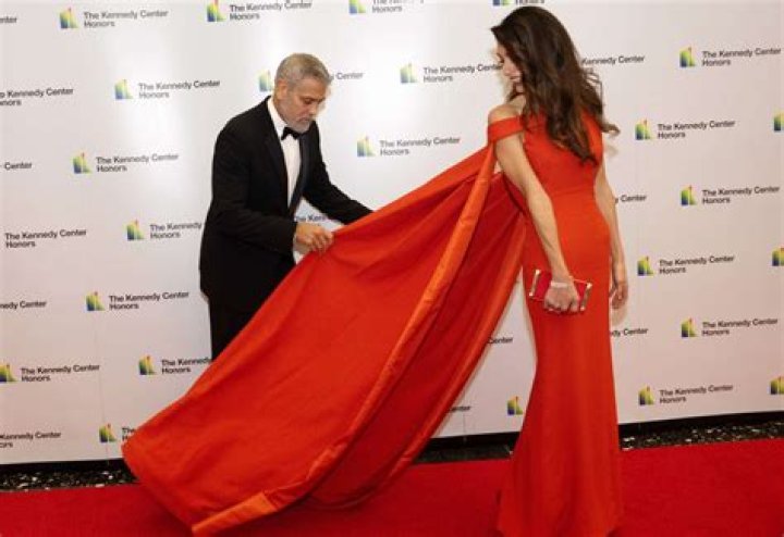 
George Clooney Fixes Wife Amal’s Dress Train While on Kennedy Center Honors Red Carpet 